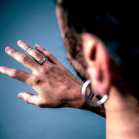 [full] Person with tattoos wearing an statement sterling silver ring