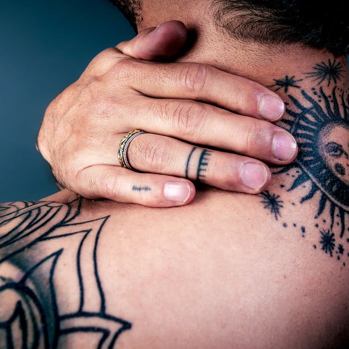 [full] Person with tattoos on shoulder and neck wearing an statement sterling silver ring