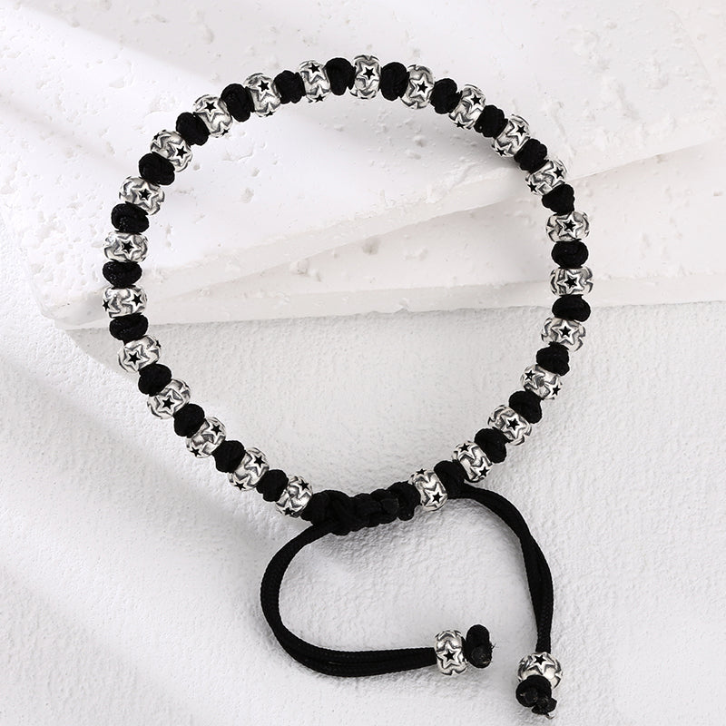 [full] - Sterling silver bracelet with star-engraved beads and black cord detailing.