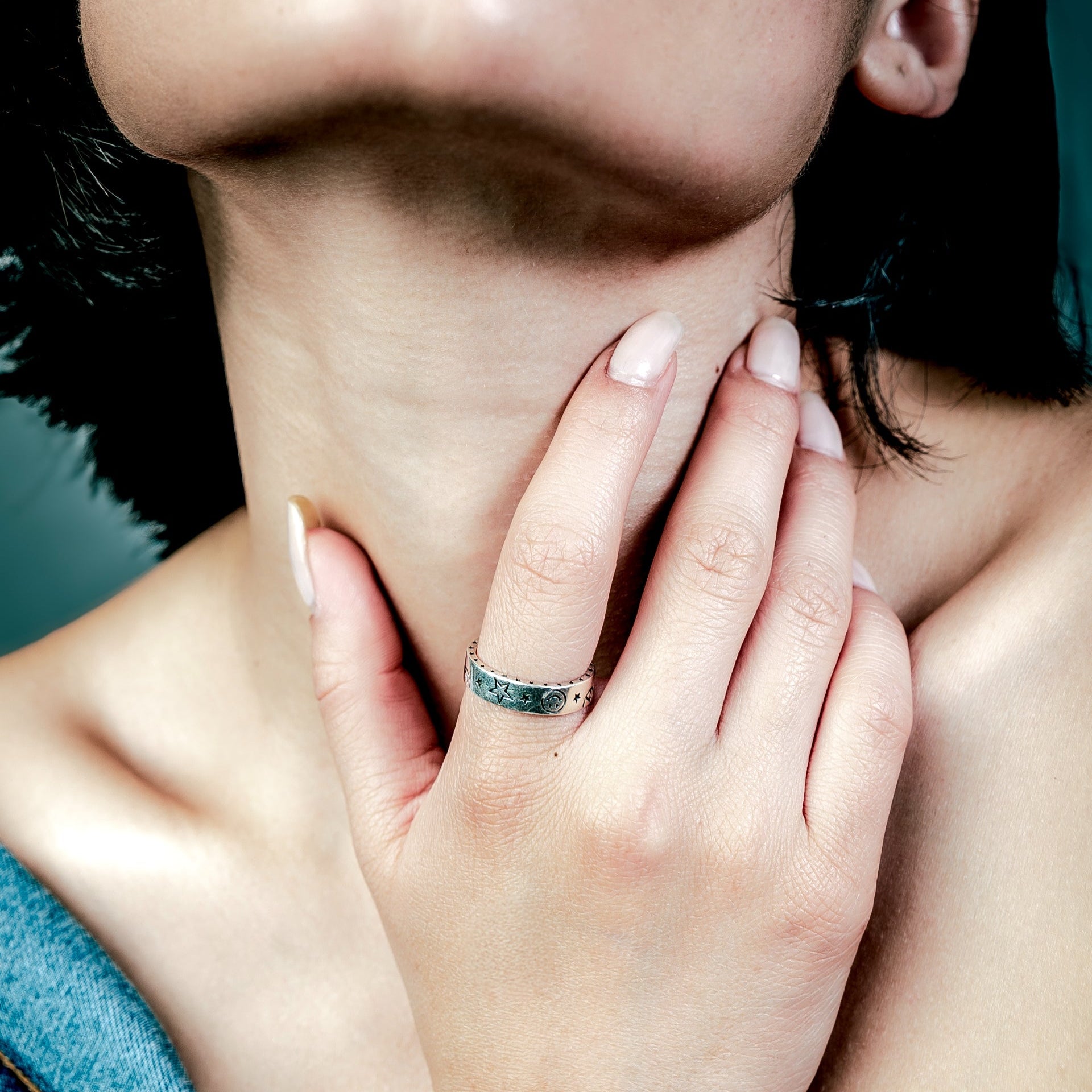 [full] Close-up of a woman with a sterling silver ring on her finger.