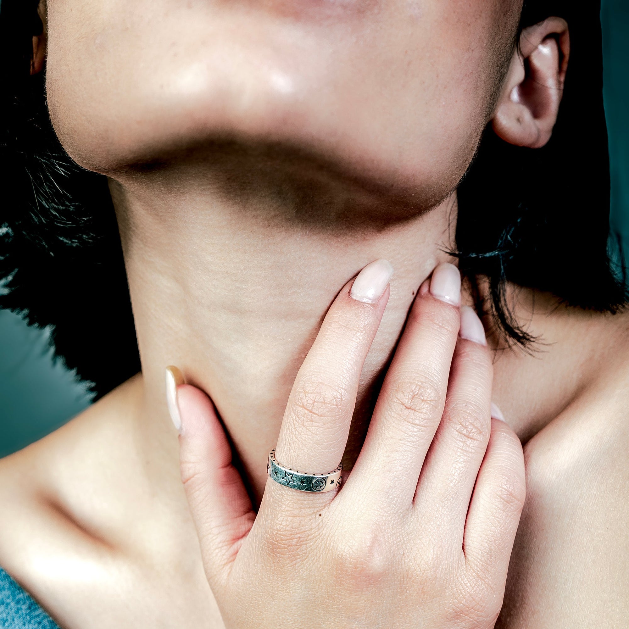 [full] Close-up of a woman with a sterling silver ring on her finger.