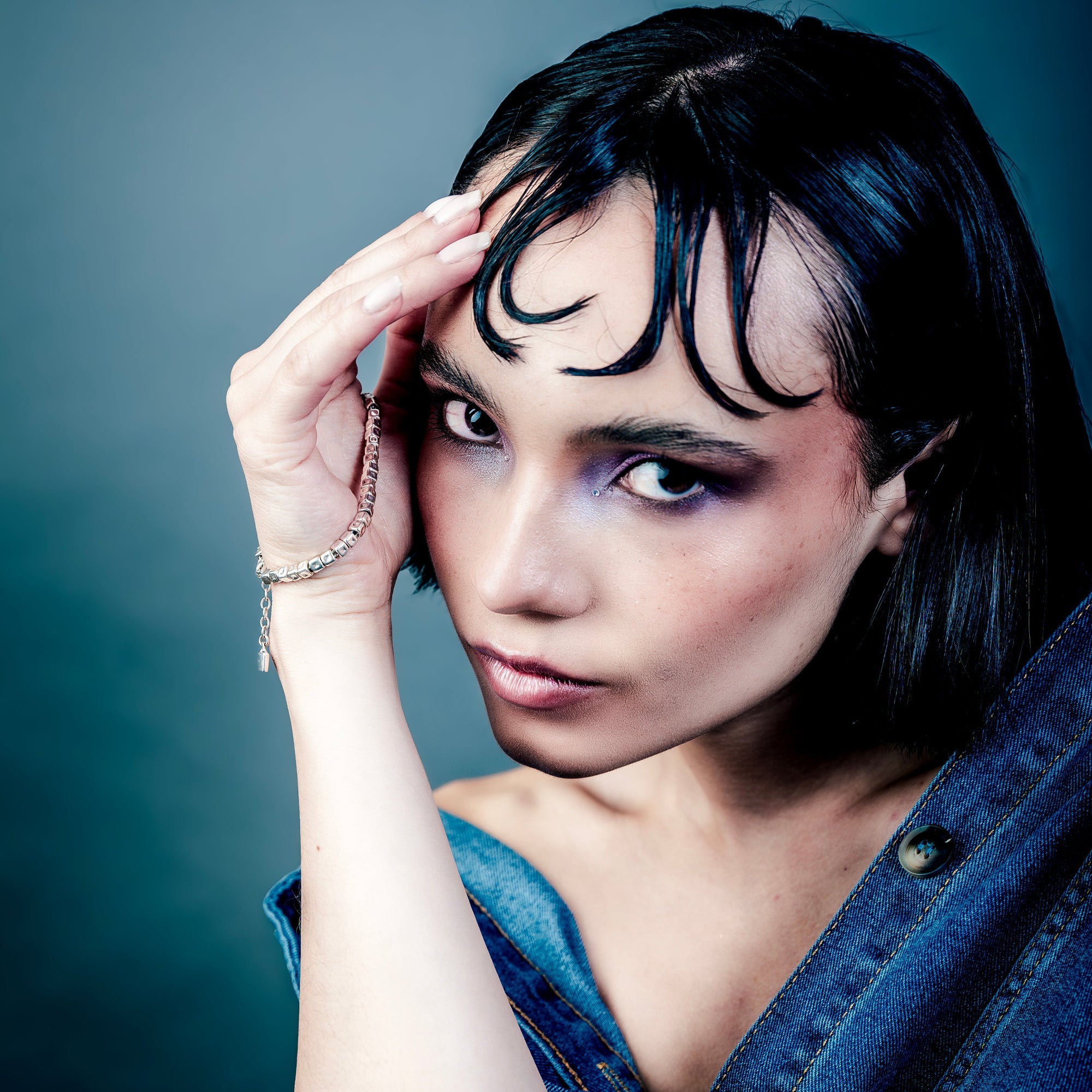[full] Woman with dark hair and denim jacket wearing a sterling silver cube beads bracelet with matte finish and adjustable closure.