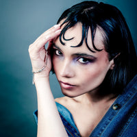 [full] Woman with dark hair and denim jacket wearing a sterling silver cube beads bracelet with matte finish and adjustable closure.