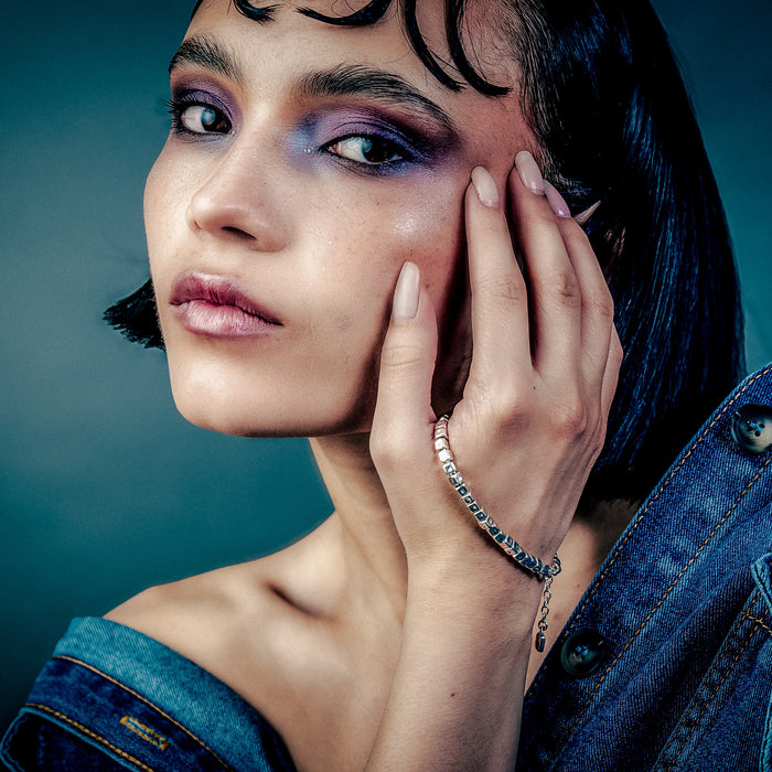[full] Woman with dark hair and denim jacket wearing a sterling silver cube beads bracelet with matte finish and adjustable closure.