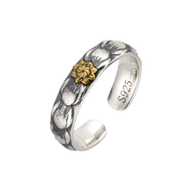 [full] Silver ring with a gold flower design on a white background