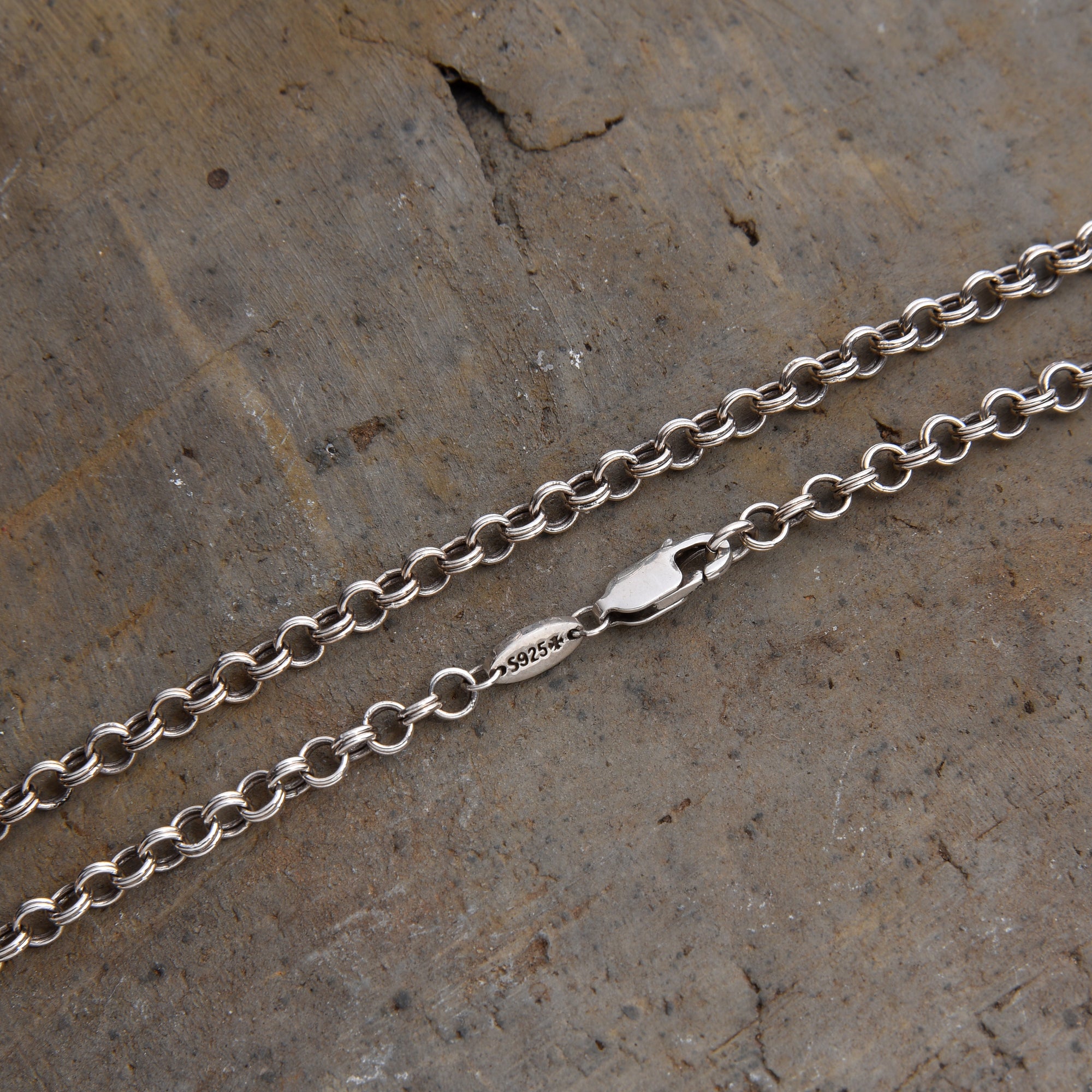 [full] - Close-up of sterling silver chain necklace with interlocking links and a fluid, modern design