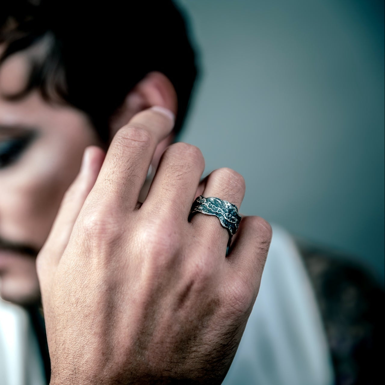 [full] Man wearing a sterling silver ring with a blurred background