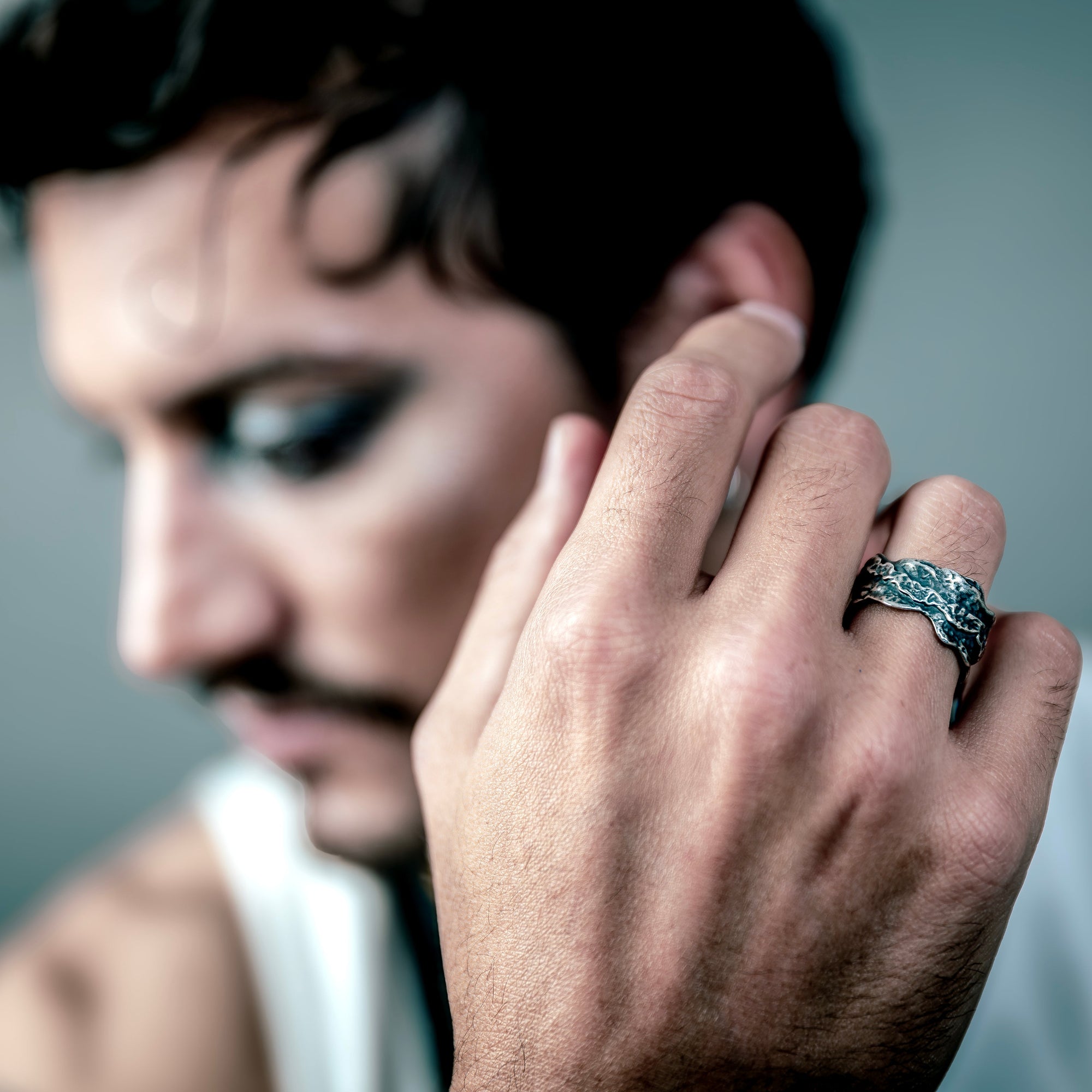 [full] Man wearing a sterling silver ring with a blurred background