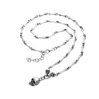 [full] - Sterling silver necklace with bone-shaped links and a detailed skull pendant.