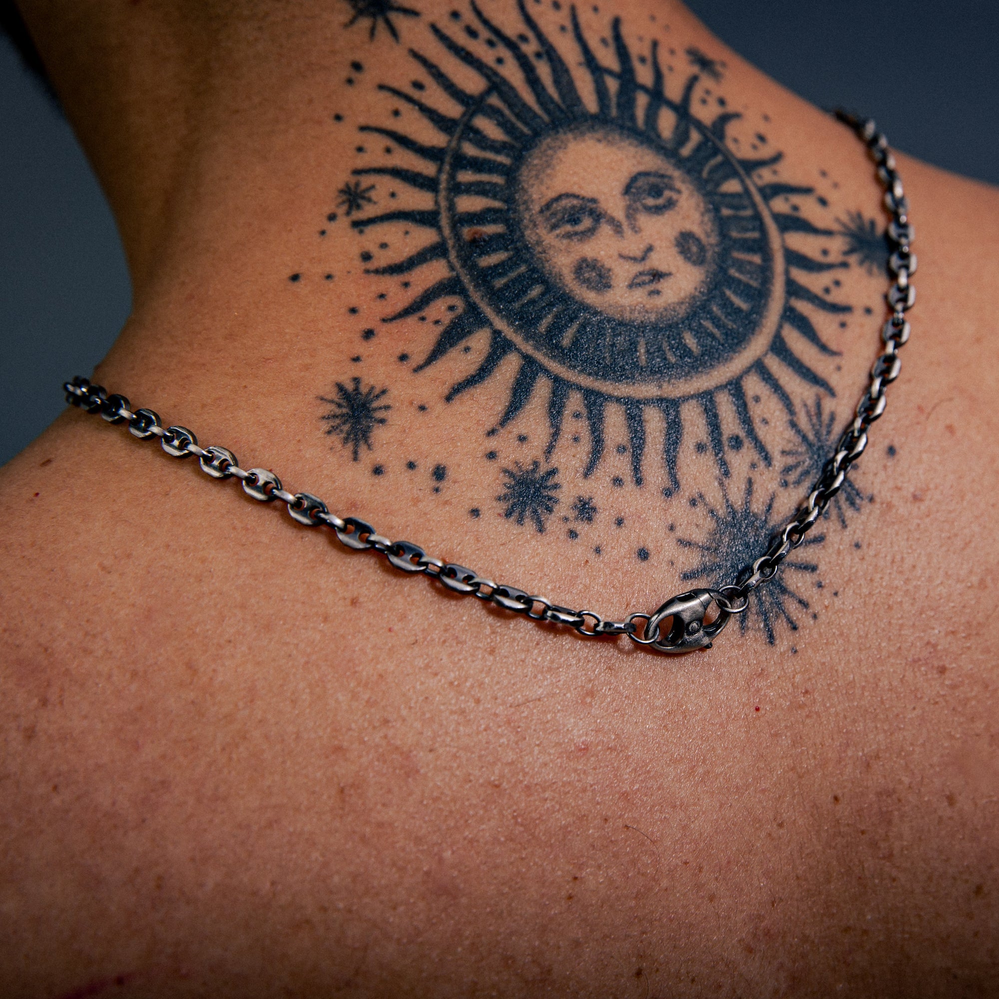 [full] Close-up of a person's back with tattoo and chain sterling silver with ruthenium plating necklace