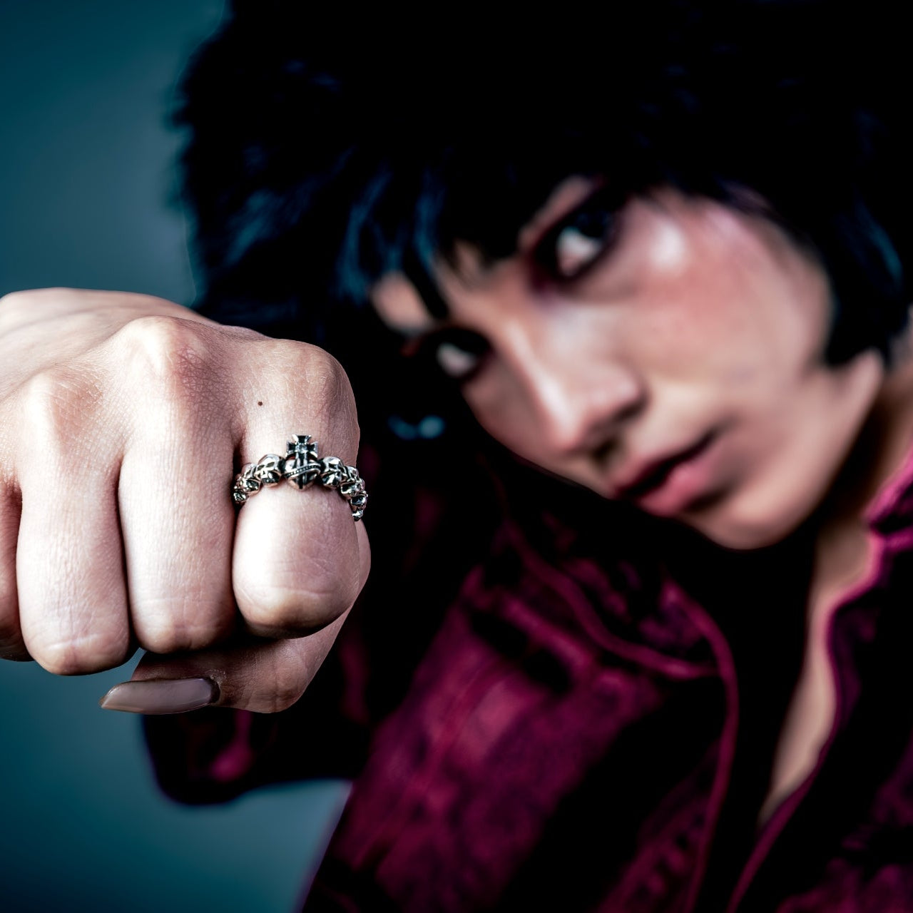 [full] Person wearing a sterling silver ring with a dark background