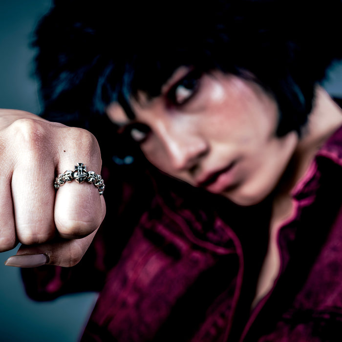 [full] Person wearing a sterling silver ring with a dark background