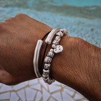 [full] Person wearing the Tempest Bracelet in 999 silver, featuring textured beads and polished accents, styled by the pool.